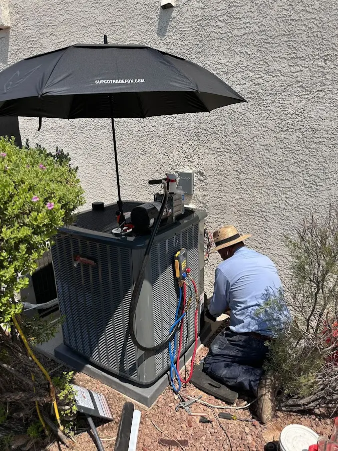 HVAC technician performing outdoor AC maintenance in Haiku-Pauwela